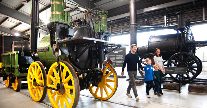 family walking past an historic engine at Locomotion railway museum